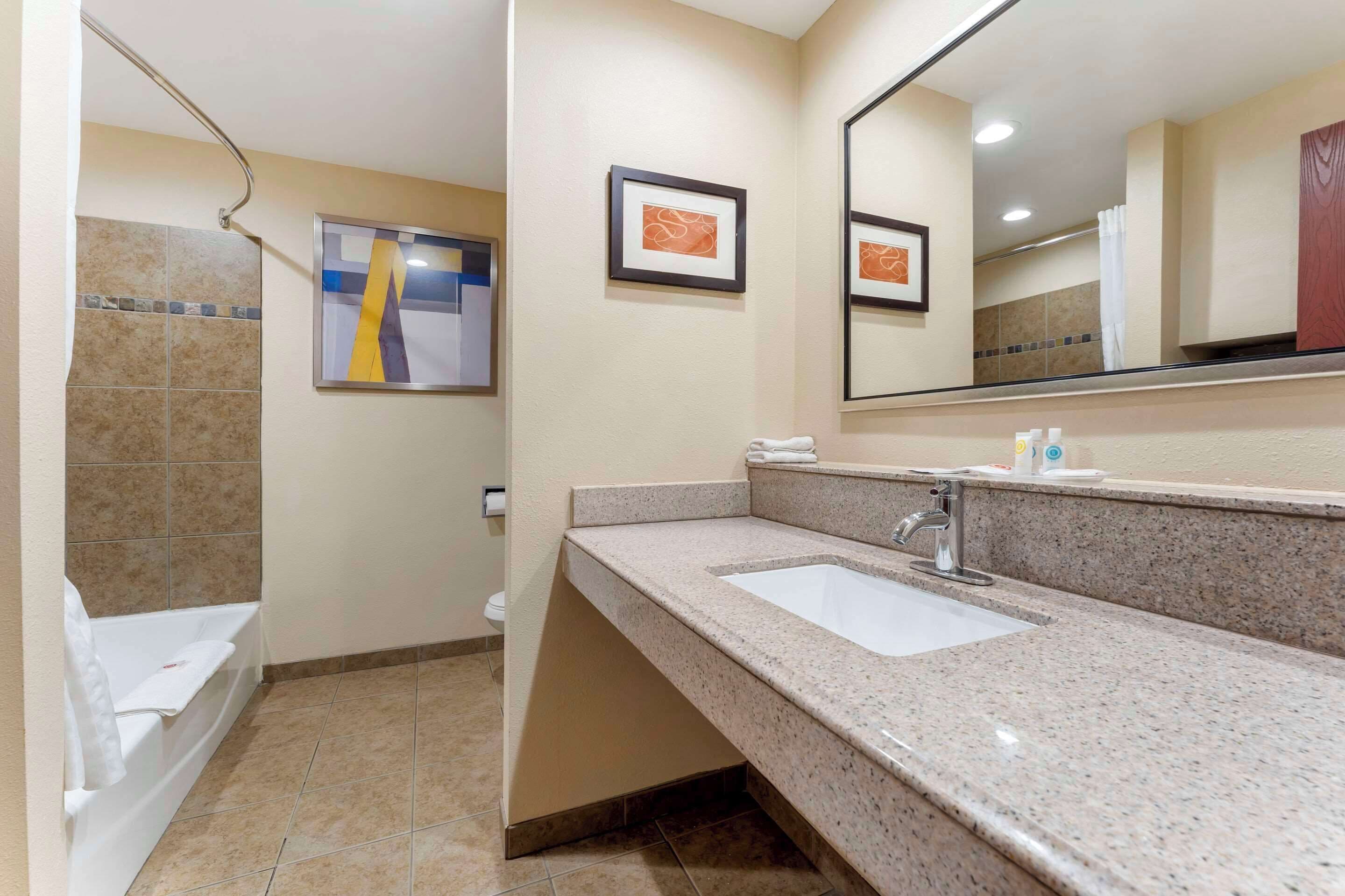 A bathroom with a sink, mirror, and towel rack.