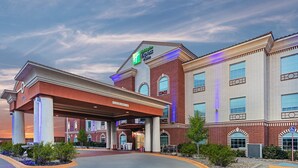 Et hotel med en tydelig indgang, et overdækket område med skiltet "Clearance II" og et skilt, der angiver "Holiday Inn Express Suites".