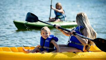 A group of people in a yellow raft on a body of water, wearing life jackets.