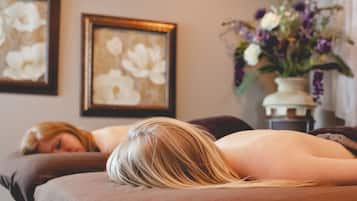 Cozy retreat with a comfortable bed, framed artwork, and a vase with fresh flowers.