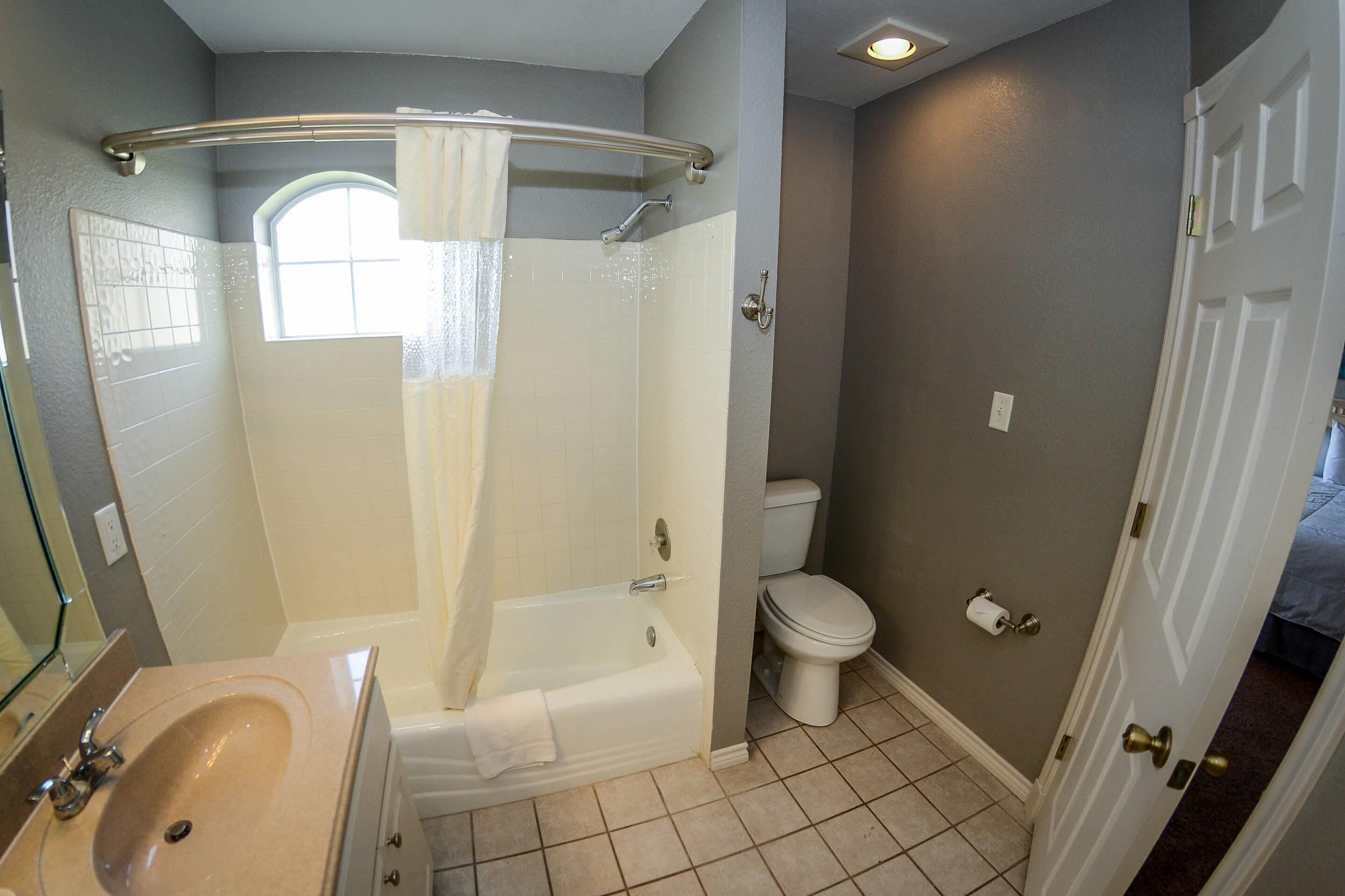 A bathroom with a bathtub, toilet, and sink.