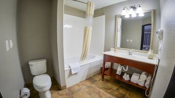 A bathroom with a toilet, bathtub, and sink.