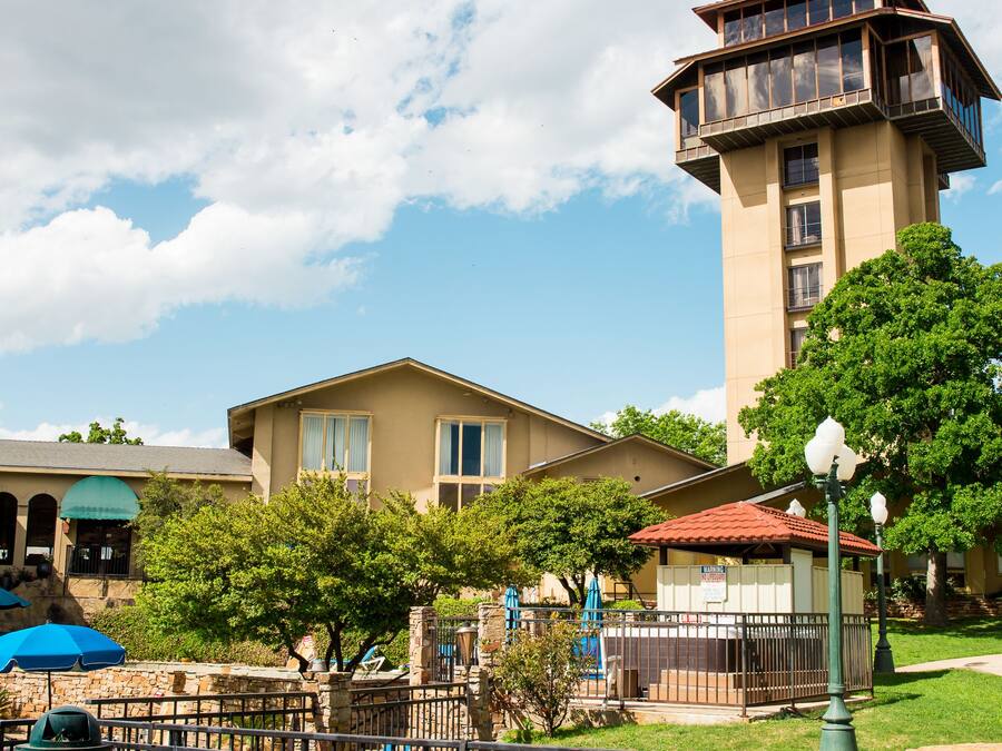A patio area with wicker furniture, a view of a building with a tower, and a clear sky.