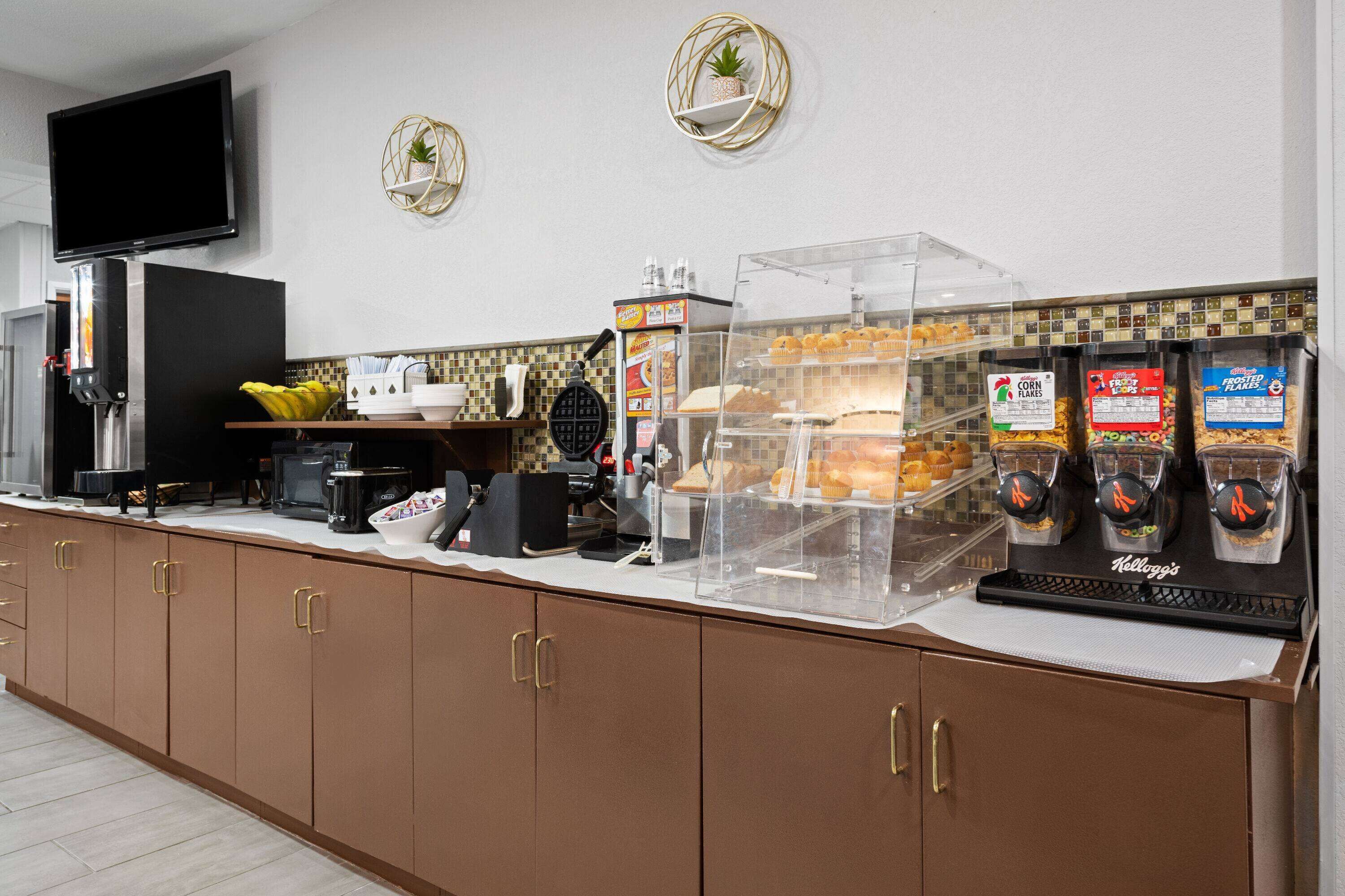 A breakfast bar with a coffee machine, cereal dispensers, and a fruit bowl.