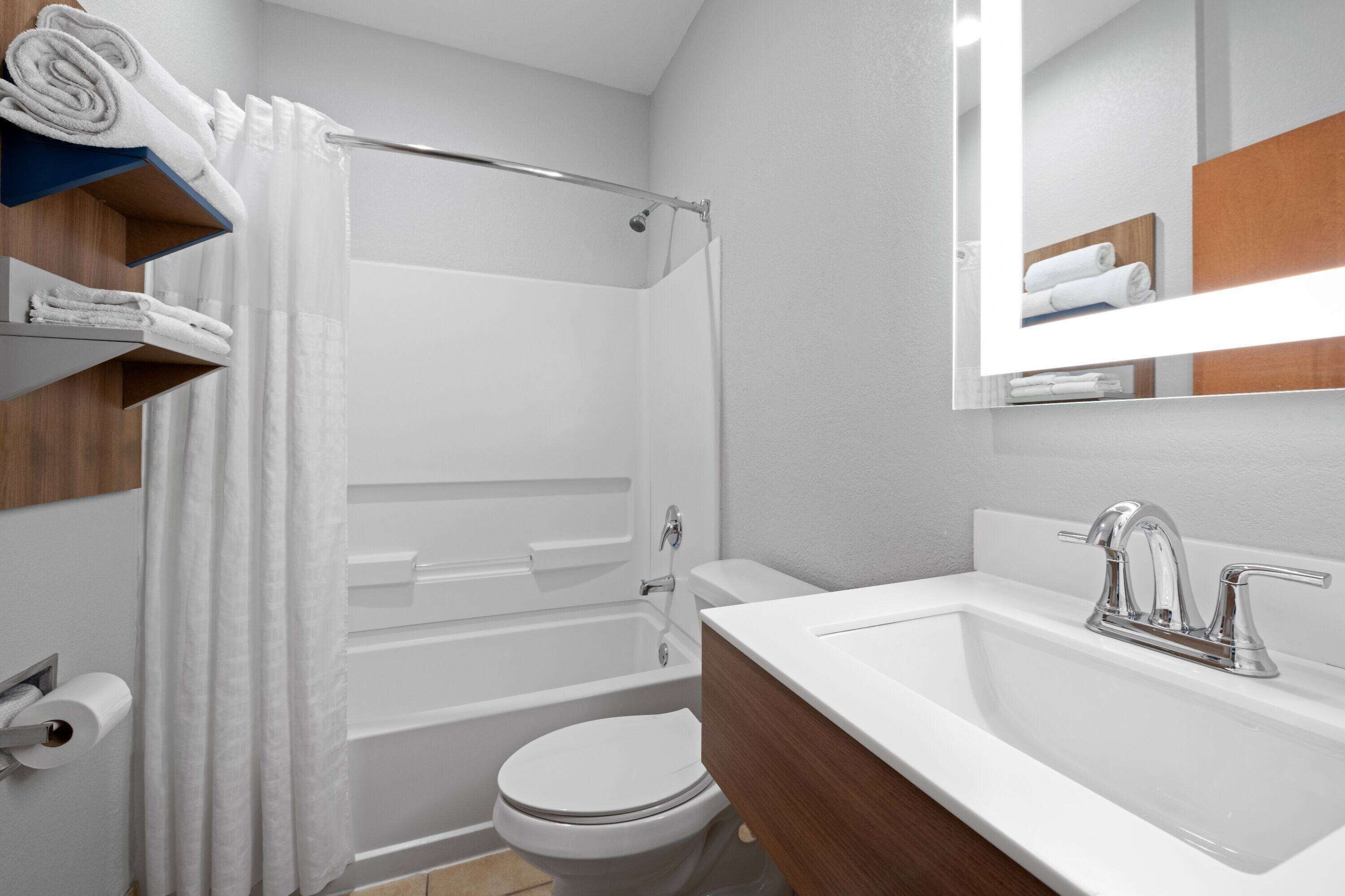 A modern bathroom with a bathtub, toilet, and sink.