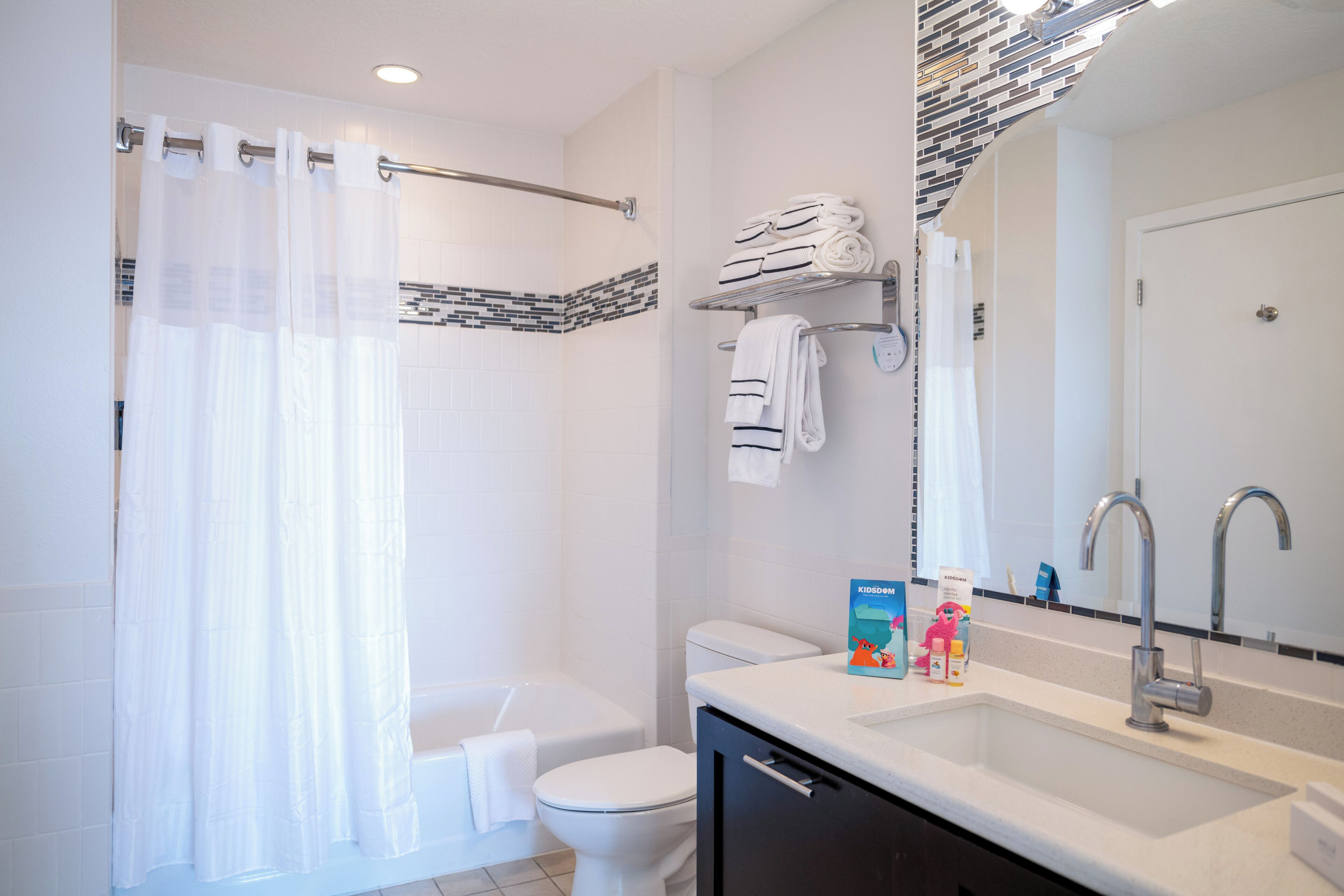 A modern bathroom with a shower, toilet, and sink.