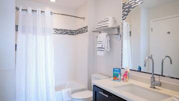 A modern bathroom with a shower, toilet, and sink.