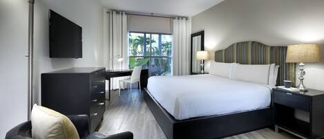 Una habitación de hotel moderna con una cama grande, un escritorio y una silla.