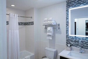 Un baño moderno con ducha, inodoro y lavamanos.