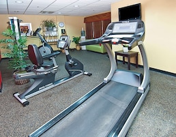 Un gimnasio de hotel con cintas de correr y bicicletas estáticas.
