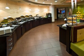 A buffet setup with multiple food stations and a seating area. - Holiday Inn Vicksburg by IHG (Vicksburg)