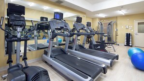 A gym with treadmills, exercise equipment, and a mirror.