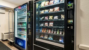 Dos máquinas expendedoras con una variedad de aperitivos y bebidas, incluyendo Coca-Cola y otras marcas.