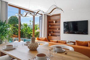 Una sala de estar moderna con comedor, piscina y vistas al exterior.