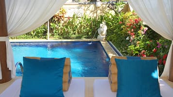 Una piscina al aire libre, camas de piscina gratis, sombrillas