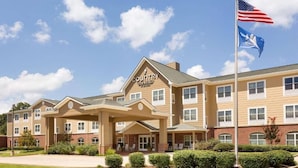 A Country Inn & Suites hotel with a two-story building, a covered entrance, and a flagpole with the American flag. - Hotel Pineville & Conference Center Alexandria I-49 (Pineville)