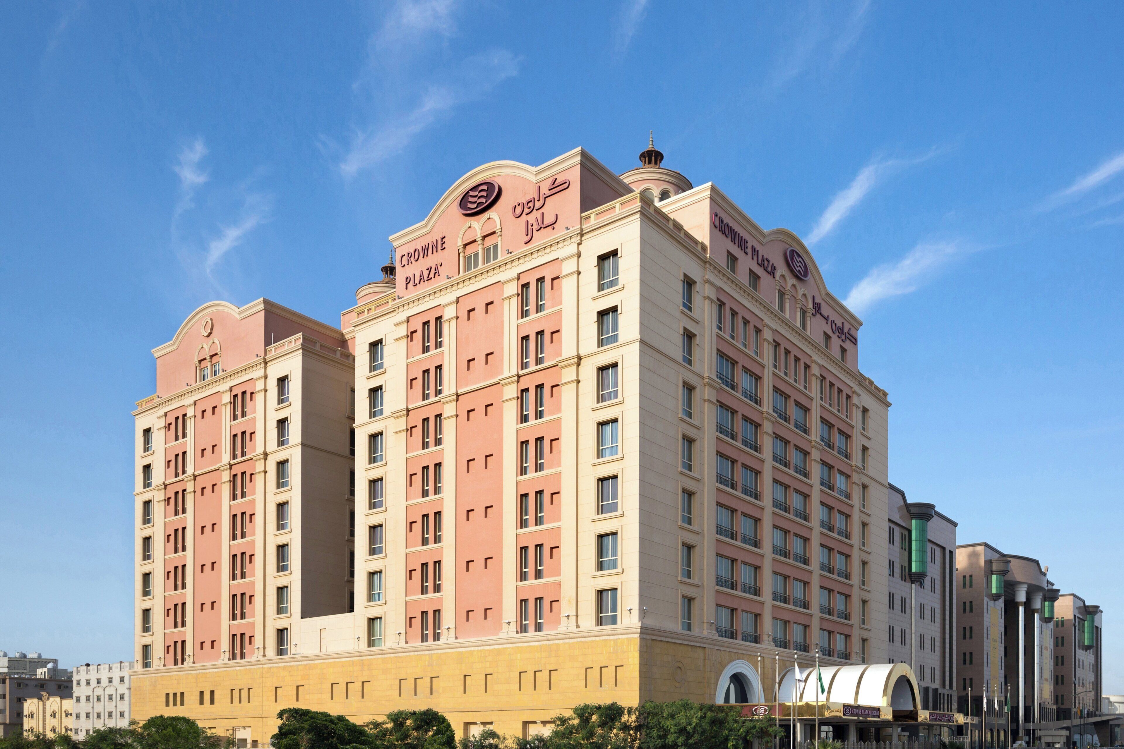 Un hotel de varios pisos con fachada simétrica, amplias ventanas y una entrada destacada.