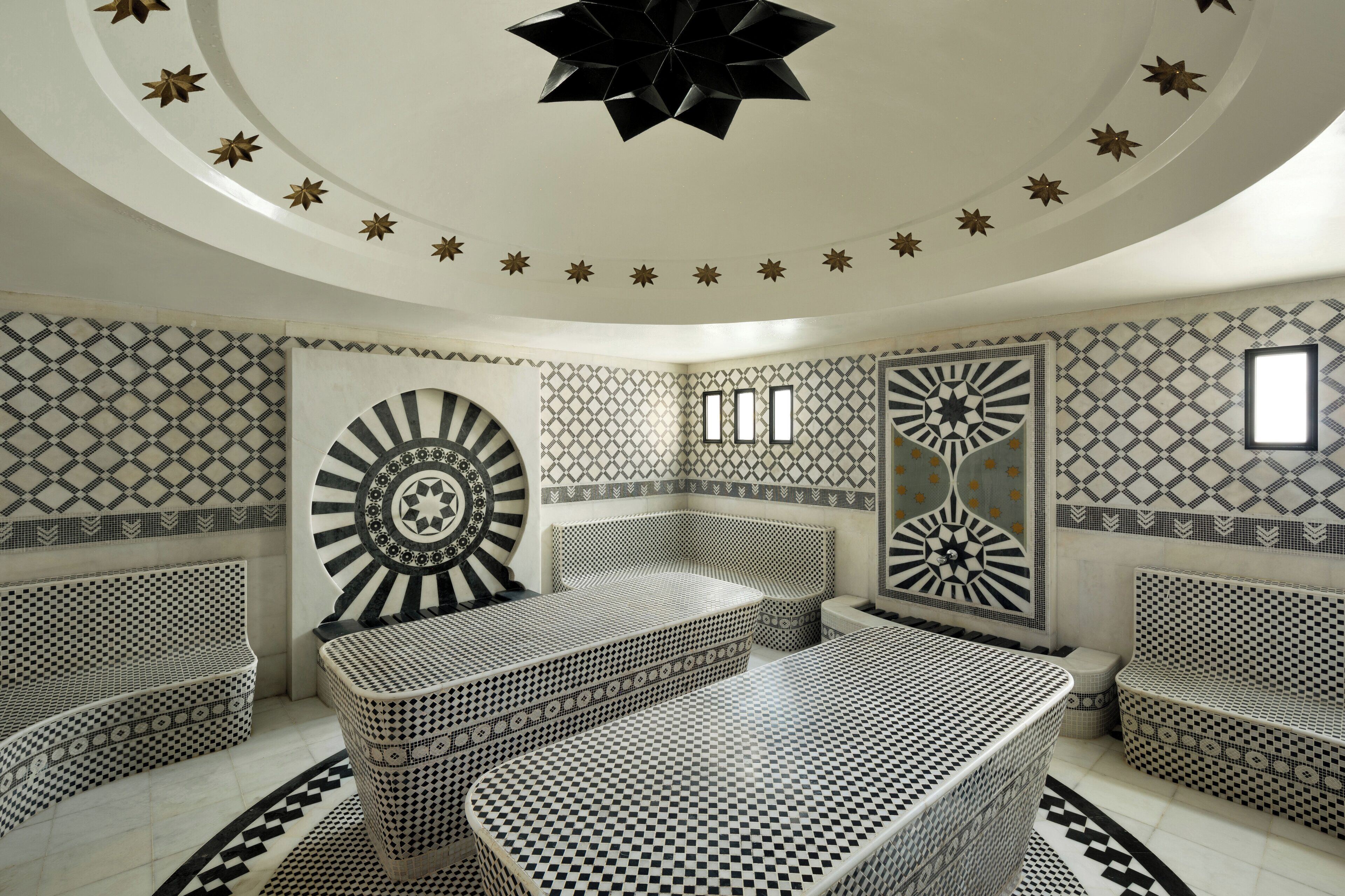 A room with a checkered floor, patterned walls, and a star-shaped ceiling ornament.