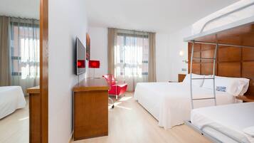 Una habitación de hotel con dos camas, un escritorio, una silla y un televisor.
