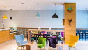 A modern library with a variety of seating options and a wall of bookshelves. - Zentral Ave (Zaragoza)
