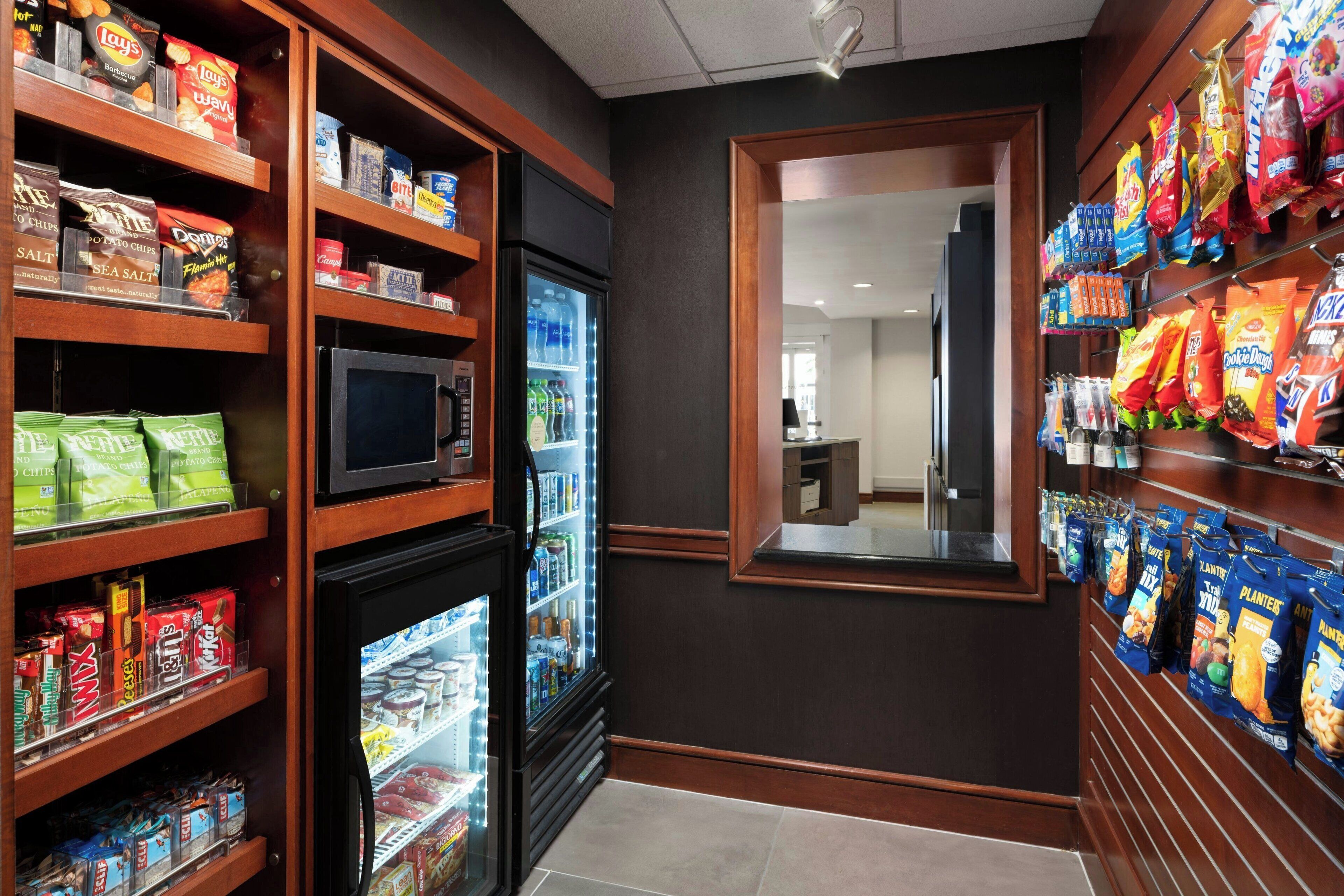 A snack and beverage area with shelves stocked with chips, snacks, and bottled drinks.