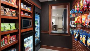 A snack and beverage area with shelves stocked with chips, snacks, and bottled drinks.