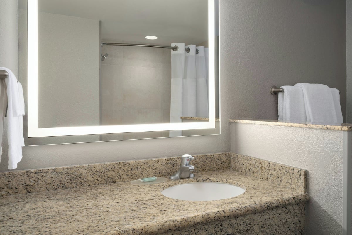 Escritorio, cortinas opacas, tabla de planchar con plancha