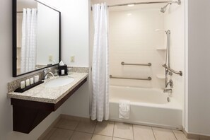A bathroom with a sink, mirror, shower, and bathtub. - Embassy Suites by Hilton Tampa Brandon (Tampa)