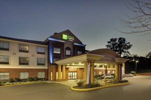 Edificio de Holiday Inn Express con fachada de ladrillo, entrada cubierta y estacionamiento.
