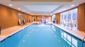 An indoor swimming pool with chairs and a staircase.