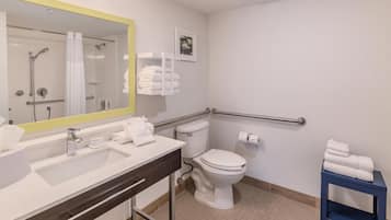 A modern bathroom with a large mirror, a sink, a toilet, and a shower.
