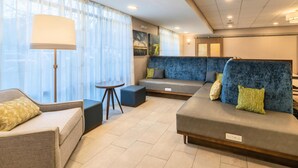 A modern living room with a sofa, armchair, and a small table. - Hampton Inn Jasper (Jasper)