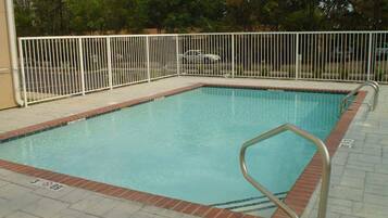 Una piscina al aire libre de temporada, sillones reclinables de piscina