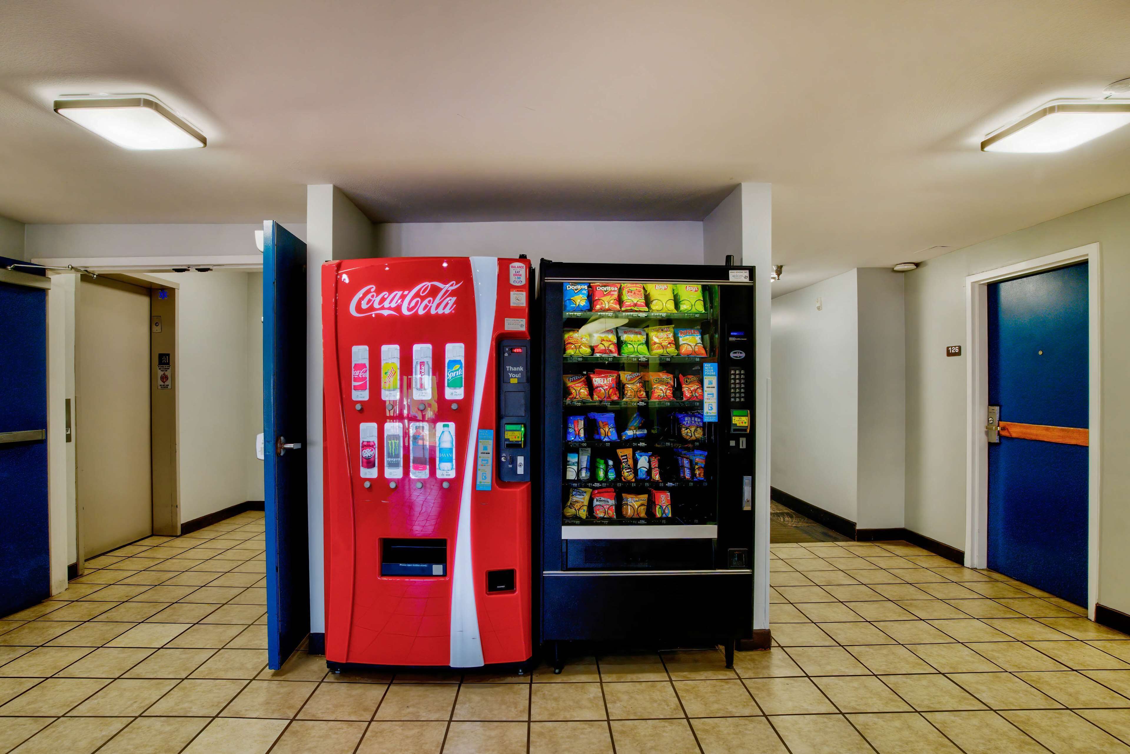 A hallway with a Coca-Cola vending machine and a snack vending machine.