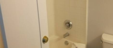 A bathroom with a bathtub, toilet, and a shower.
