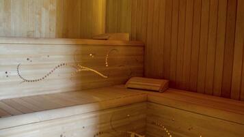 A wooden sauna with benches and a bucket.