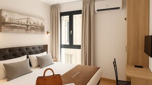 Una habitación de hotel moderna con una cama grande, un escritorio y una silla.