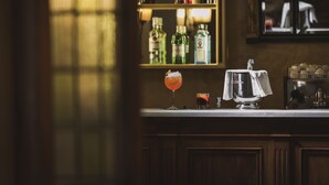 Zona de bar con mostrador, botellas y vasos.