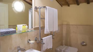 Ein Badezimmer mit einer Glasablage, einem Handtuchhalter, einer Toilette und einem Waschbecken.