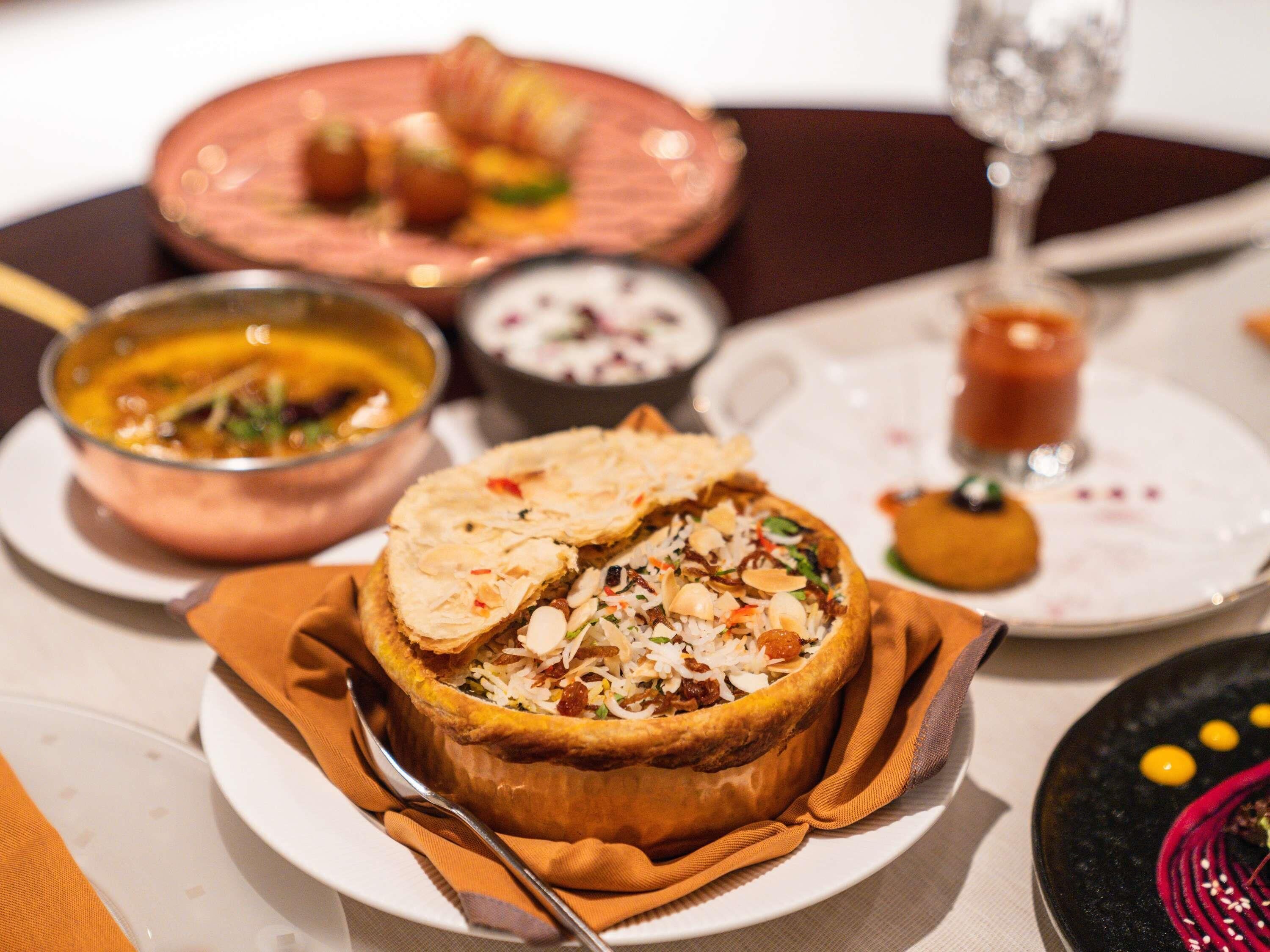 A dining table with a variety of dishes, including a stuffed pastry and a bowl of soup.