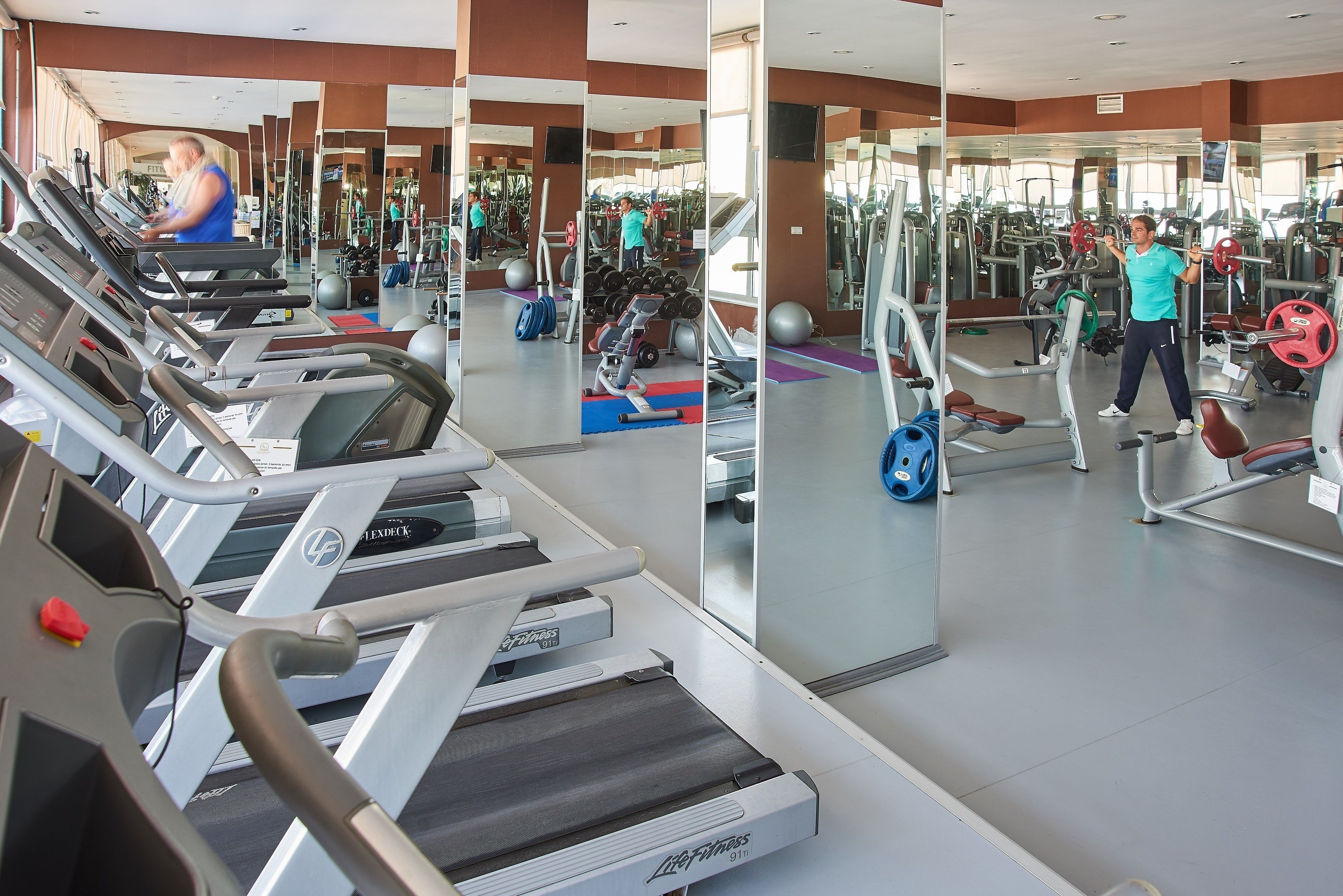 A gym with treadmills, weight machines, and mirrors.