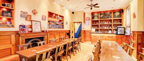Un restaurante con mobiliario de madera, una mesa larga y estantes con botellas.