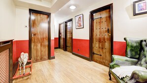 A hotel hallway with wooden doors, a red and white color scheme, a green armchair, and a small horse sculpture. - Church Street Hotel by Belvilla near Kings College Hospital (London)