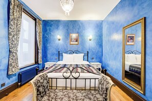 A bedroom with a large bed, a nightstand, a dresser, a mirror, and a chandelier. - Church Street Hotel by Belvilla near Kings College Hospital (London)