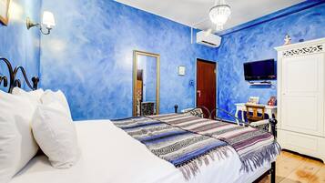 Ein Schlafzimmer mit einem großen Bett, einem Schminktisch, einem Fernseher und einem Spiegel.