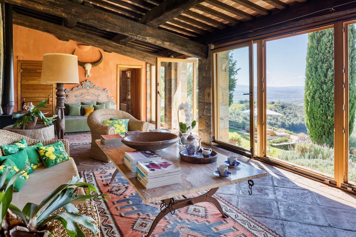 Un salón acogedor con una gran mesa de madera, asientos cómodos y vistas al campo.