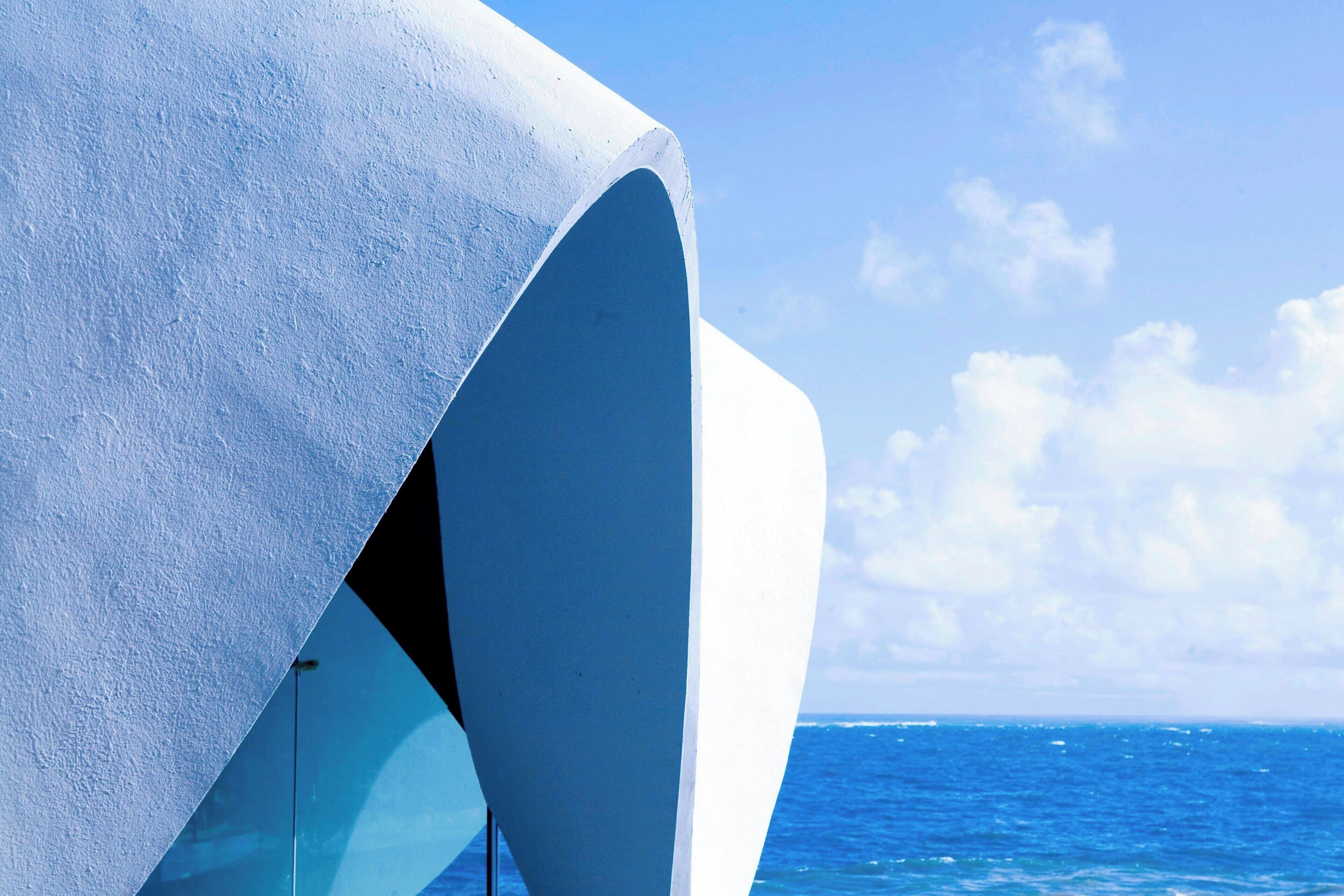 Un bâtiment moderne à l’architecture originale, caractérisée par des courbes, situé en bord de mer.
