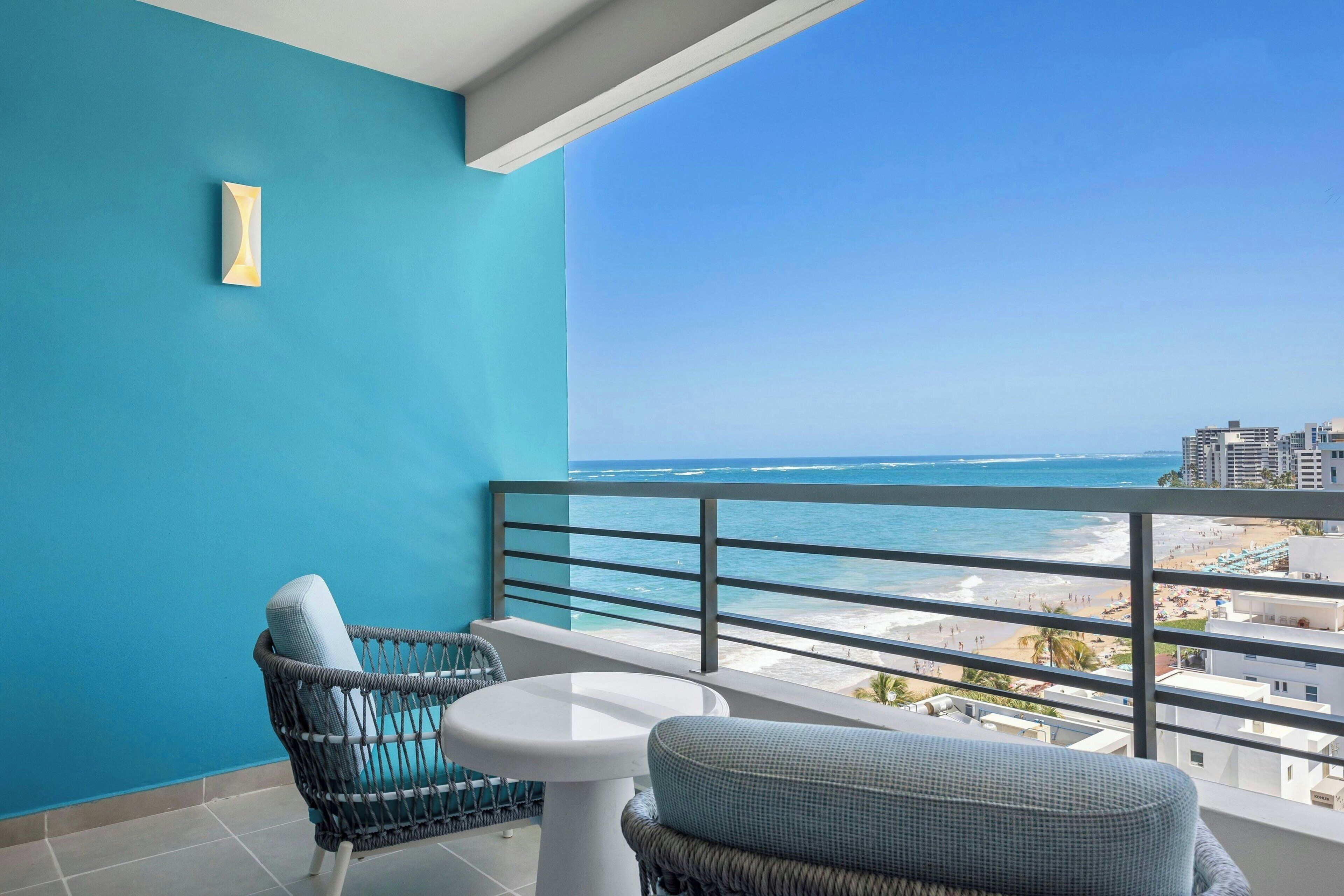 A balcony with a view of the beach and ocean.