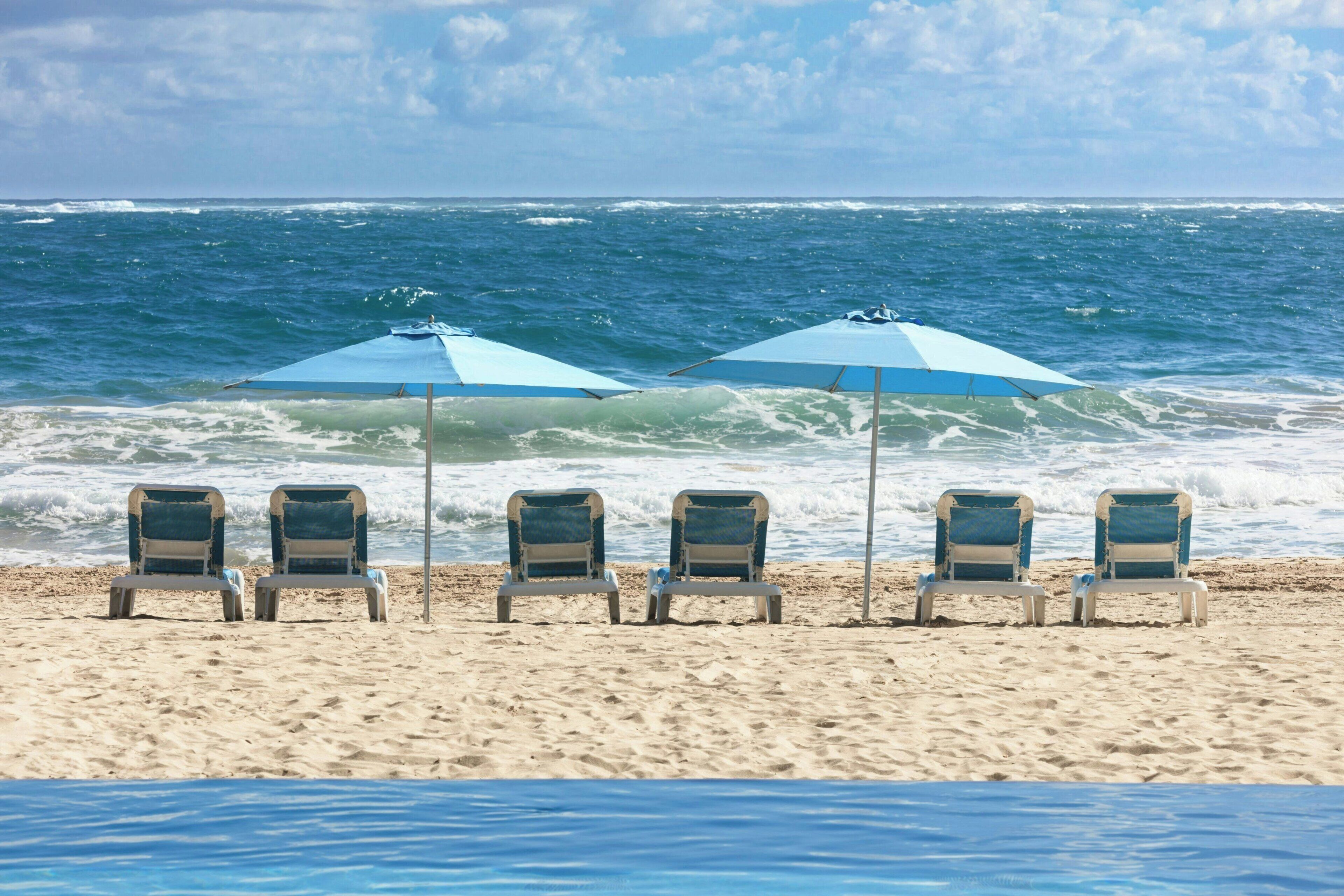 On the beach, white sand, sun loungers, beach umbrellas