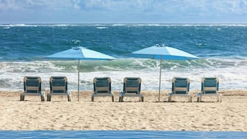 On the beach, white sand, sun loungers, beach umbrellas